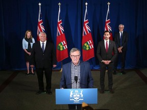 Dr. David Williams, Chief Medical Officer of Health for Ontario, speaks as Health Minister Christine Elliott, rear left to right, Premier Doug Ford, Education Minister Stephen Lecce and Ontario's chief coroner Dr. Dirk Huyer look on during a COVID-19 press briefing at Queen's Park. All of these people, and more, convey public messages to Ontarians. No wonder there's a communications muddle.