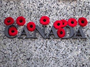 Poppies are seen on the National War Memorial after Remembrance Day ceremonies, in Ottawa on Sunday, Nov. 11, 2018.