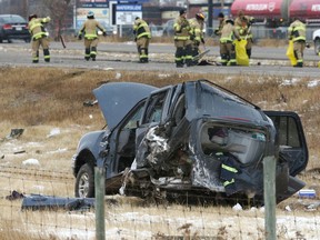 Firefighters clean up a large debris field following a fatal accident in the town of Strathmore, Alta., on Oct. 18.