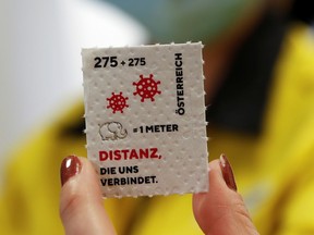 An employee of the Austrian postal service displays a so called "corona stamp" in a post office, as the 2.75 euro "corona stamp" is printed on three-ply toilet paper and sold individually as part of a 10 cm wide sheet, in Vienna, Austria October 23, 2020.