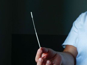 File photo: A nurse holds a nose swab in a hospital.