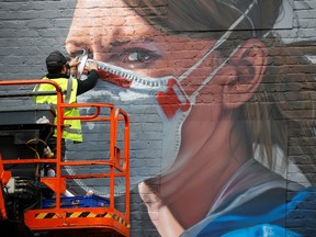 An artist works on a mural as the coronavirus disease (COVID-19) outbreak continues, in Manchester, Britain October 18, 2020.