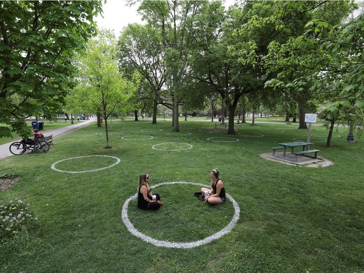  Women sit in a field where circles were painted to help visitors maintain social distancing to slow the spread of the coronavirus disease (COVID-19) at Trinity Bellwoods park in Toronto, Ontario, Canada May 28, 2020.
