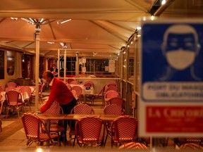 A waiter cleans a table of "La Chicoree" restaurant a few minutes before the start of the late-night curfew due to restrictions against the spread of the coronavirus disease (COVID-19), in Lille, France, October 16, 2020.