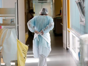 A doctor, wearing a protective mask and a protective suit, works in a pulmonology unit.