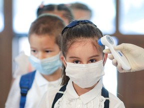 FILE PHOTO: A school nurse measures the temperature of children arriving for the first day of school during the coronavirus outbreak in Bucharest, Romania.