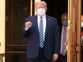 U.S. President Donald Trump makes a fist as he walks out the front doors of Walter Reed National Military Medical Center after a fourth day of treatment for the coronavirus disease (COVID-19) while returning to the White House in Washington from the hospital in Bethesda, Maryland, U.S., October 5, 2020. REUTERS/Jonathan Ernst ORG XMIT: WAS406