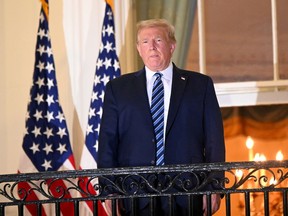 FILE PHOTO: U.S. President Donald Trump poses atop the Truman Balcony of the White House after taking off his protective face mask as he returns to the White House after being hospitalized at Walter Reed Medical Center for coronavirus disease (COVID-19) treatment, in Washington, U.S. October 5, 2020.