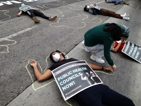 Protesters lie in the road outside the LA Board of Supervisors during a die-in protest and memorial service honoring the over 6,800 people from LA who died from the coronavirus disease (COVID-19), in Los Angeles, California, U.S., October 21, 2020.