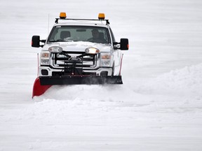 A truck plows through snow.