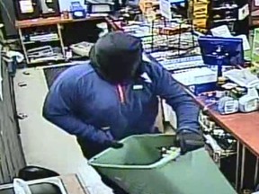 Man with piece of clothing on his head flees Manotick convenience store with laundry basket full of cigarettes.