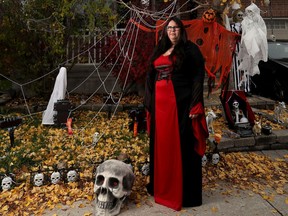 Crystal Smalldon poses for a photo in her yard beside her Halloween decorations in Ottawa. Crystal has organized a Halloween "Spookby" in Kanata, Stittsville and Carp to deliver candy and pick up food bank donations.