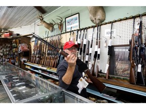 U.S. President Donald Trump supporter Richard Albrecht, a sales associate at Nordic Gun & Pawn, displays a shotgun for a customer, in Wildwood, Fla.
