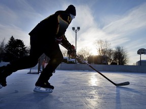 Tyler Mezger looks for a pass while playing a little shinney on the outdoor rink with buddies John Mitchell and Jordan Lackey at Manordale Park on Knoxdale Rd.
