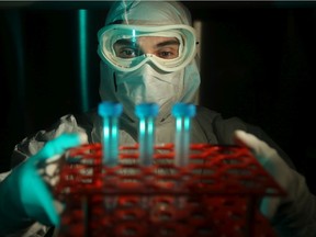 Manufacturing Associate Leon Barbeau looks at a sample under the clean hood in Biotherapeutics Manufacturing Centre's lab at the The Ottawa Hospital.