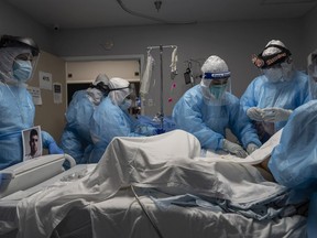 HOUSTON, TX - OCTOBER 31: Medical staff members treat a patient suffering from the coronavirus disease (COVID-19) in the COVID-19 intensive care unit (ICU) at the United Memorial Medical Center (UMMC) on October 31, 2020 in Houston, Texas.