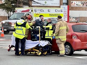 Emergency personnel tend to the driver of one of two vehicles involved in an accident at the intersection of Carling Avenue and Alpine Avenue.