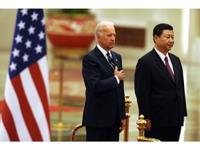 Then-vice-president Joe Biden listens to the U.S. national anthem with Xi Jinping during a welcome ceremony in the Great Hall of the People in Beijing on August 18, 2011.