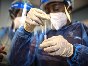 FILE: A medical worker puts a swab in a tube after as she performed an antigen test for COVID-19.