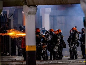 Brazilian military police clash with demonstrators during a protest at the entrance of a Carrefour supermaket where Joao Alberto Silveira Freitas was beaten to death, in Porto Alegre, Rio Grande do Sul, Brazil, on November 20, 2020.