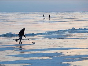 People skate and play hockey on frozen Lake Ontario during sunset in Kingston, Ont. on Jan. 26, 2019. Newly published research says climate change is making familiar winter activities on frozen lakes and rivers more dangerous.