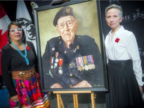 A ceremony was held to honour the service of Philip Favel at the Canadian War Museum on Sunday, Nov. 8, 2020. Favel's granddaughter, Nadine Favel, and artist Elaine Goble stand beside the portrait of Philip that Goble painted.