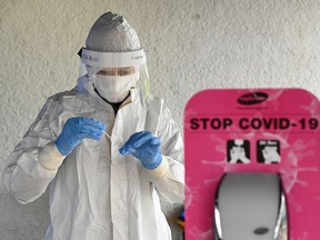 A healthcare worker tests a sample at a coronavirus disease