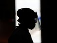 A healthcare worker wearing a full personal protective equipment (PPE) is seen as she collects swab samples.