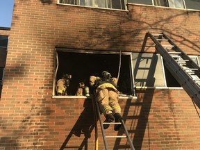 Ottawa firefighters at work evacuating family from smokey fire in city's south end.