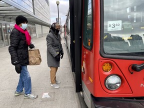 OTTAWA -- Women board an OC Transpo bus on Mackenzie King bridge on Wednesday, Nov. 18, 2020