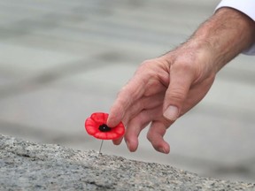 Remembrance Day ceremony at the National War Memorial in Ottawa in 2020. A war veteran leaves his poppy on the tomb of the unknown soldier.