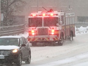 An Ottawa fire truck heads to an emergency call during snowy conditions in Ottawa on Wednesday.