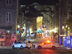 Police cars block St-Louis Street near the Chateau Frontenac in Quebec City, Sunday, Nov. 1, 2020. Carl Girouard, the 24-year-old man accused of first-degree murder in the Quebec City Halloween night sword attack, will undergo a psychiatric evaluation.
