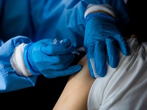 A nurse administers a flu shot vaccine to a patient