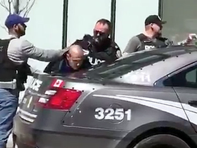 Police arrest Alek Minassian after a van fatally struck pedestrians in Toronto on Monday, April 23, 2018.