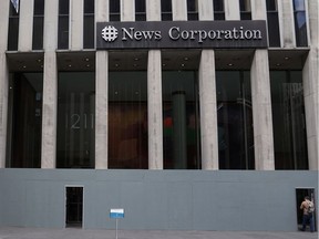 A woman walks past the boarded up News Corporation headquarters building that houses Fox News in New York City, November 2, 2020.