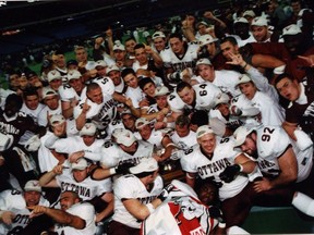 Gee-Gees player celebrate with the Vanier Cup trophy after defeating the Regina Rams in the 2000 Canadian university football championship game in Toronto.
