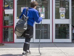 A young hockey player waits for the doors to open at a city-owned arena.