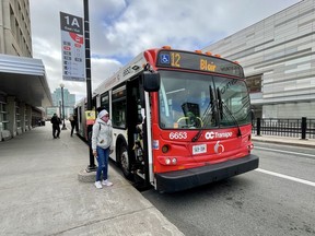 A passenger prepares to board an OC Transpo bus on Mackenzie King bridge.