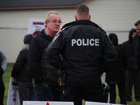 MPP Randy Hillier chats with a Cornwall officer before the start of the Cornwall March for Freedom on Saturday, November 21, 2020, in Cornwall, Ont