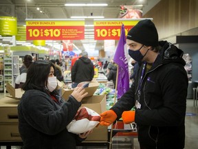 Health-care worker Ana Lyn receives her turkey from Francis Allard, an SEIU Healthcare union repat the Real Canadian Superstore in Westboro, Saturday.