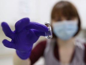 FILE: An NHS pharmacy technician at the Royal Free Hospital, London, simulates the preparation of the Pfizer vaccine to support staff training ahead of the rollout, on December 5, 2020 in London, England.