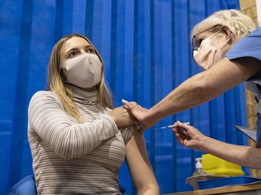 A woman is given a Pfizer-BioNTech Covid-19 vaccine. It's coming, folks.