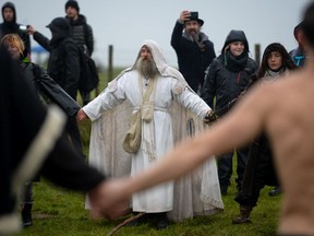 WILTSHIRE, ENGLAND - DECEMBER 21: Participants take part in a ceremony at the closed Stonehenge on December 21, 2020 in Amesbury, United Kingdom. English Heritage, which manages the site, said 'Owing to the pandemic, and in the interests of public health, there will be no Winter Solstice gathering at Stonehenge this year. We look forward to welcoming people back for solstice next year.'