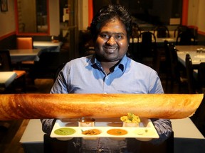 Dosas and Curries owner and chef, Vijay Krishna Rangarajan, with the downtown restaurant's Paper Masala Dosa dish.