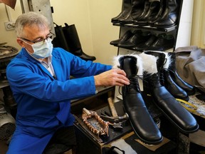 Romanian cobbler Grigore Lup presents a pair of oversized winter boots after finishing them, in his workshop in Cluj-Napoca, Romania, December 2, 2020.