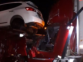 A car rests on the roof of a transport truck after a collision Tuesday morning. The driver was freed by Ottawa firefighters.