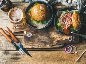 Beef burgers with crispy bacon, vegetables, glass of beer