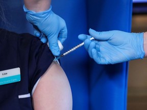 FILE: A member of staff at the Abercorn House Care Home receives a dose of the Pfizer-BioNTech COVID-19 vaccine in Hamilton, western Scotland, on December 14, 2020.