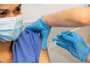 A health care worker receives an injection of the Pfizer-BioNTech Covid-19 vaccine.